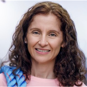 Woman with curly brown hair smiles, holding a blue rope.