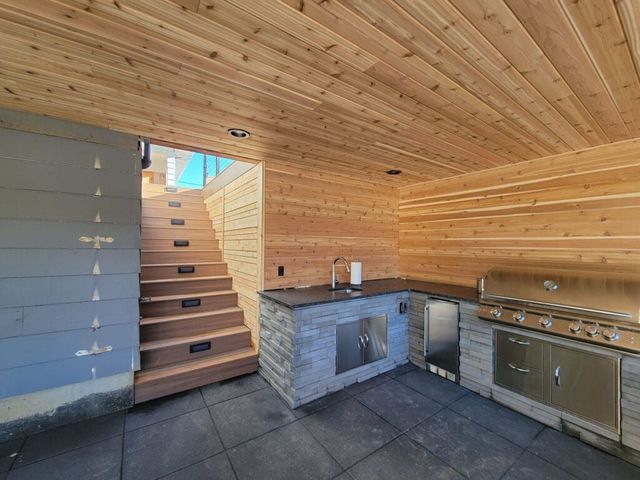 an outdoor kitchen with patio cover