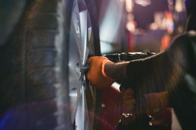A close up of a person changing a tire on a car. A close up of a person changing a tire on a car.