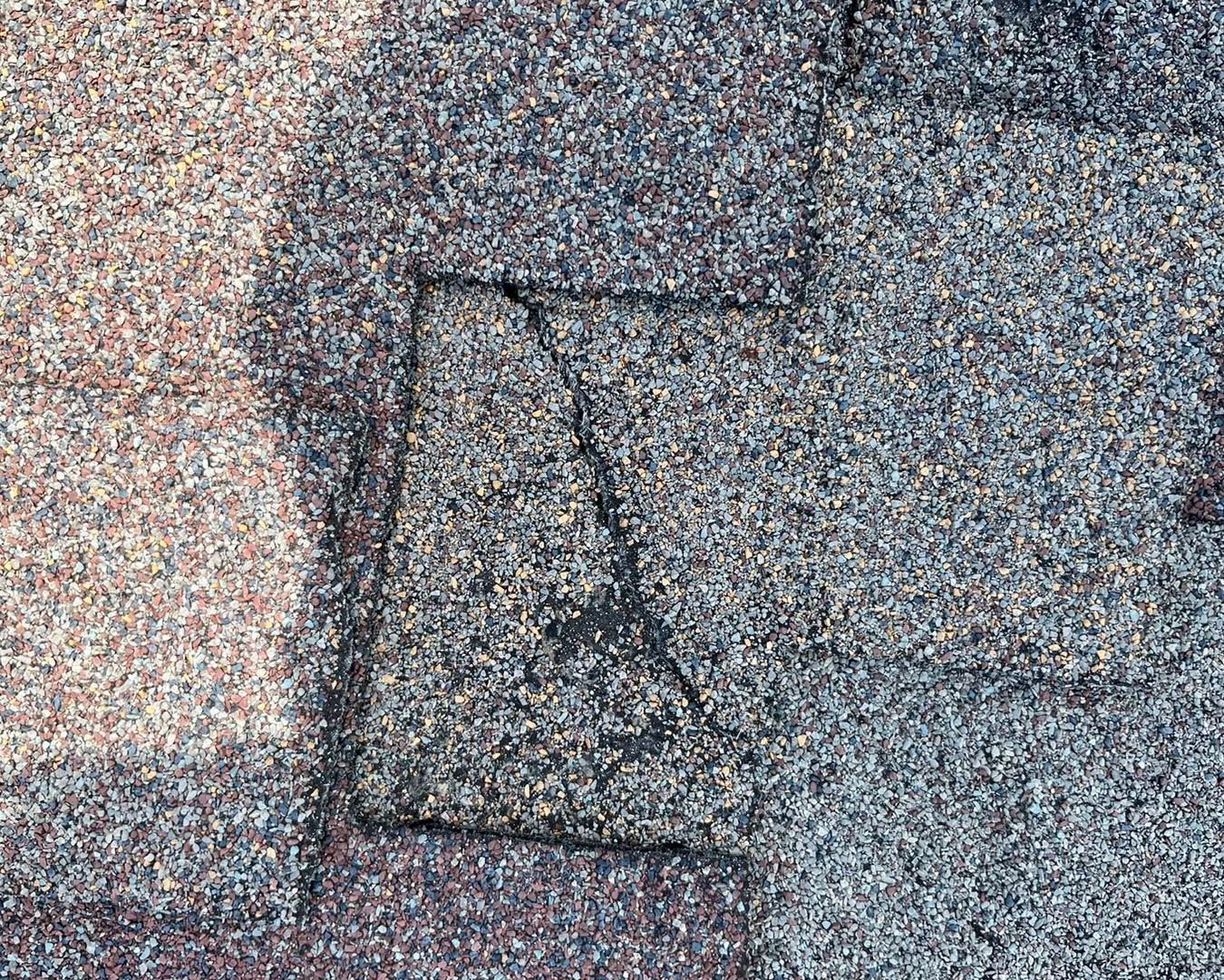 Damaged shingle still attached to the roof