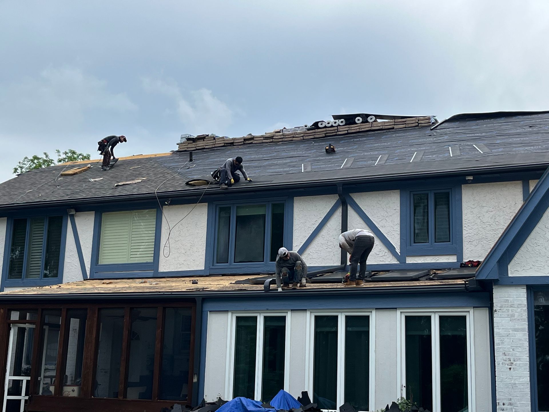 Roofing crew on roof installing shingles