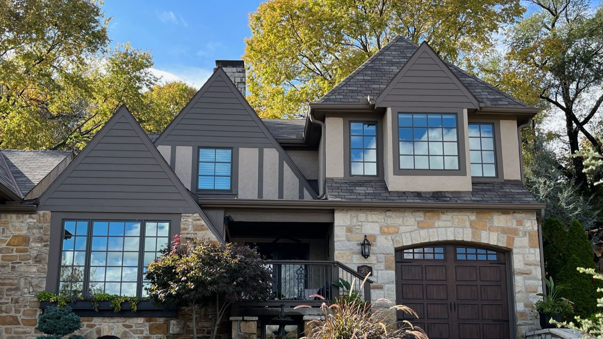 A large house with a lot of windows and a brown garage door.