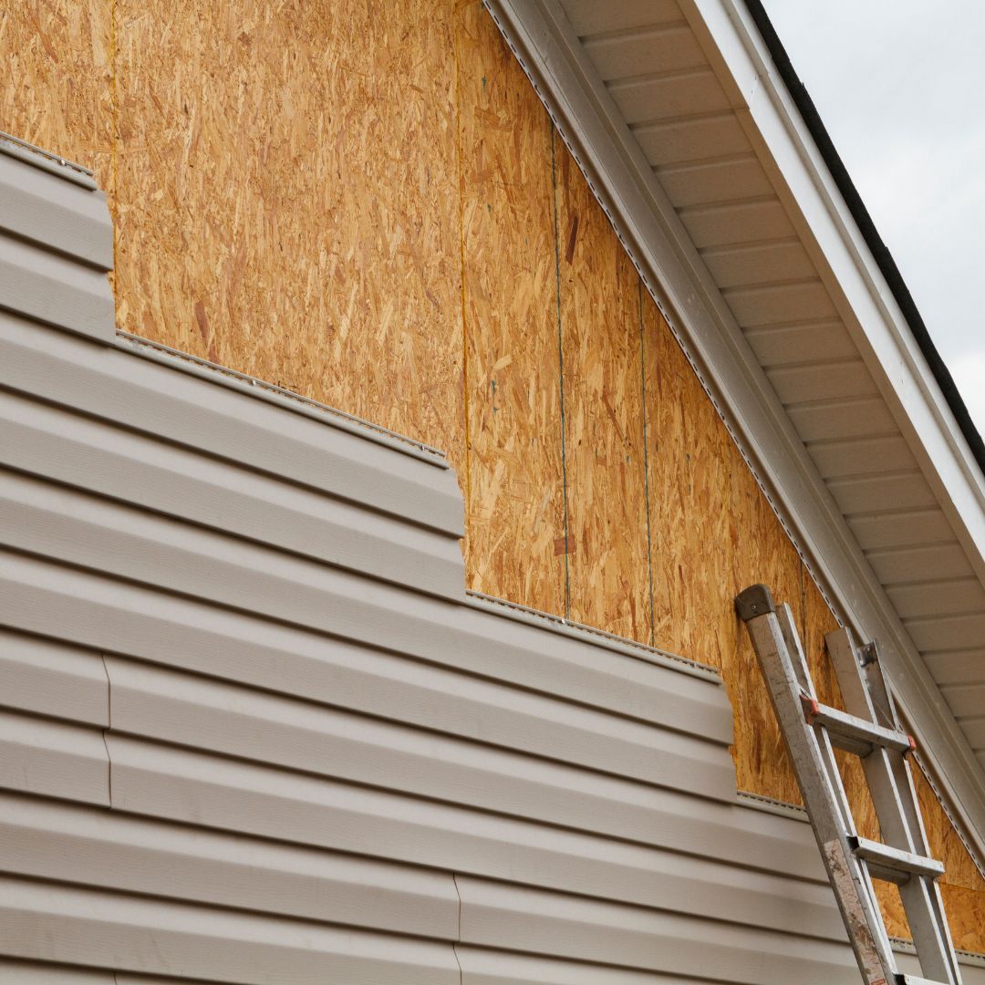 A ladder is sitting on the side of a house.