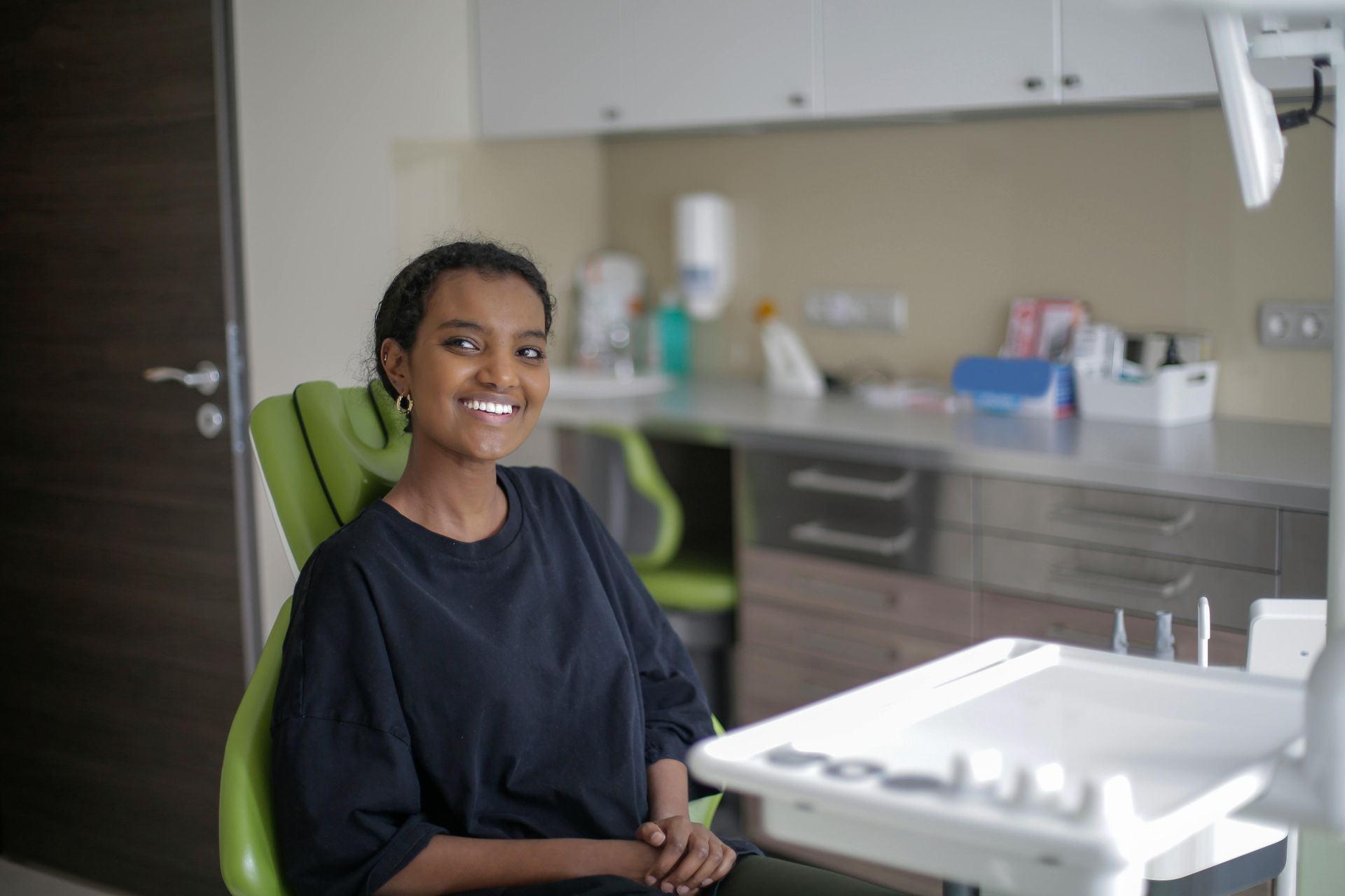 A woman is examining a man 's teeth in a dental office.