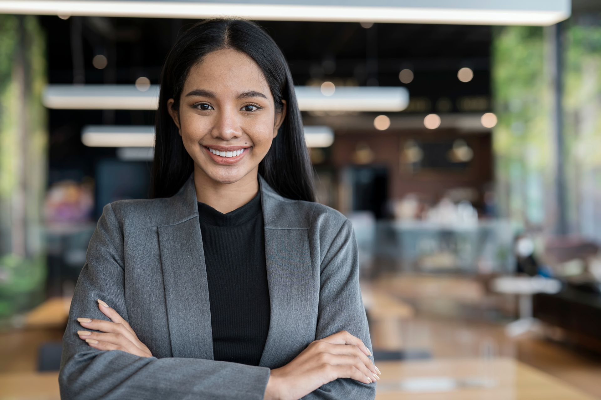 An agent from George Gandy Insurance offers insurance as she smiles and stands with her arms crossed in Artesia, NM.