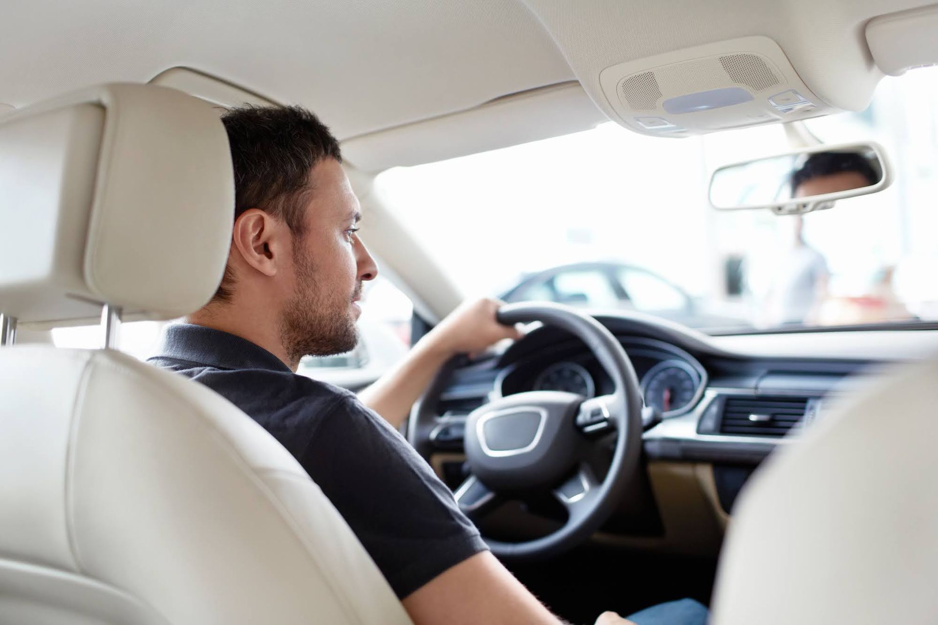 Man driving a modern car, viewed from the back seat. Man driving a modern car, viewed from the back seat.