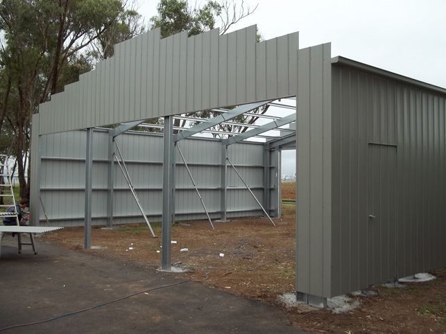 A large metal structure is being built in a field.