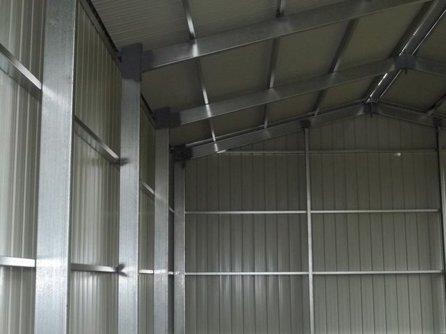 The inside of a metal building with a roof and walls.