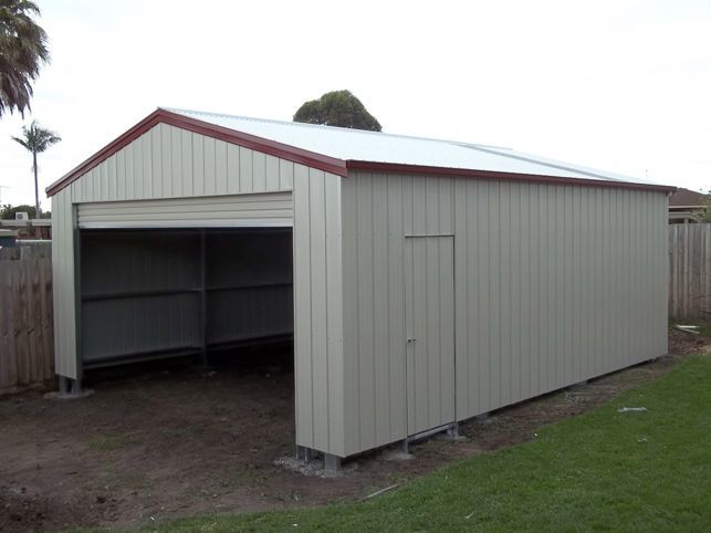 A white garage with a red roof and a door