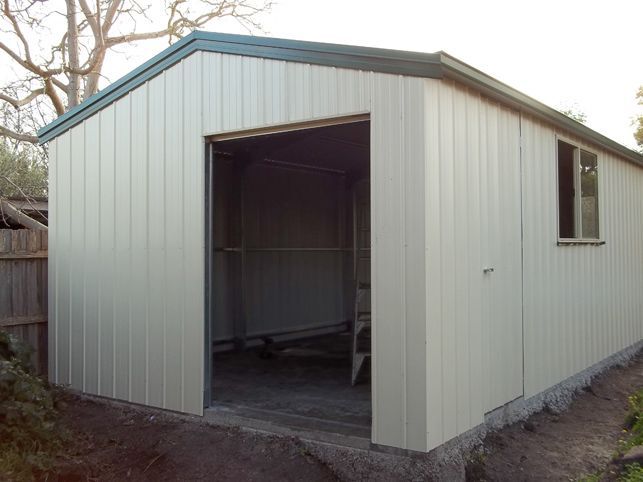 A white garage with the door open and a window