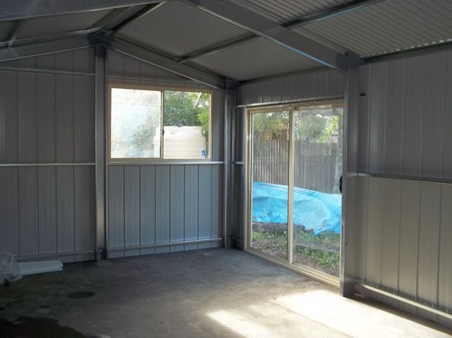 An empty room with a sliding glass door and a window.