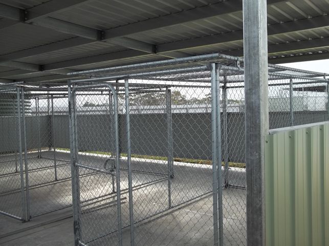 A chain link fence in a building with a roof