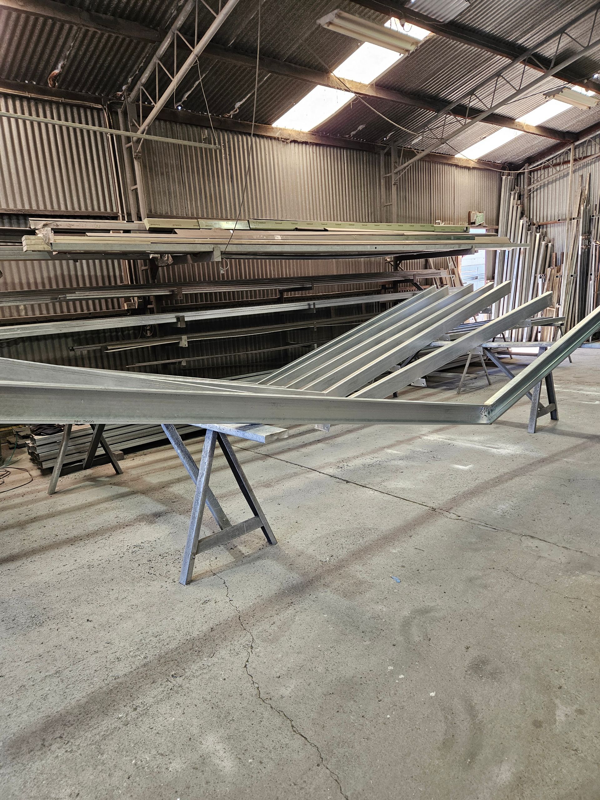 A large metal structure is sitting on a table in a warehouse.
