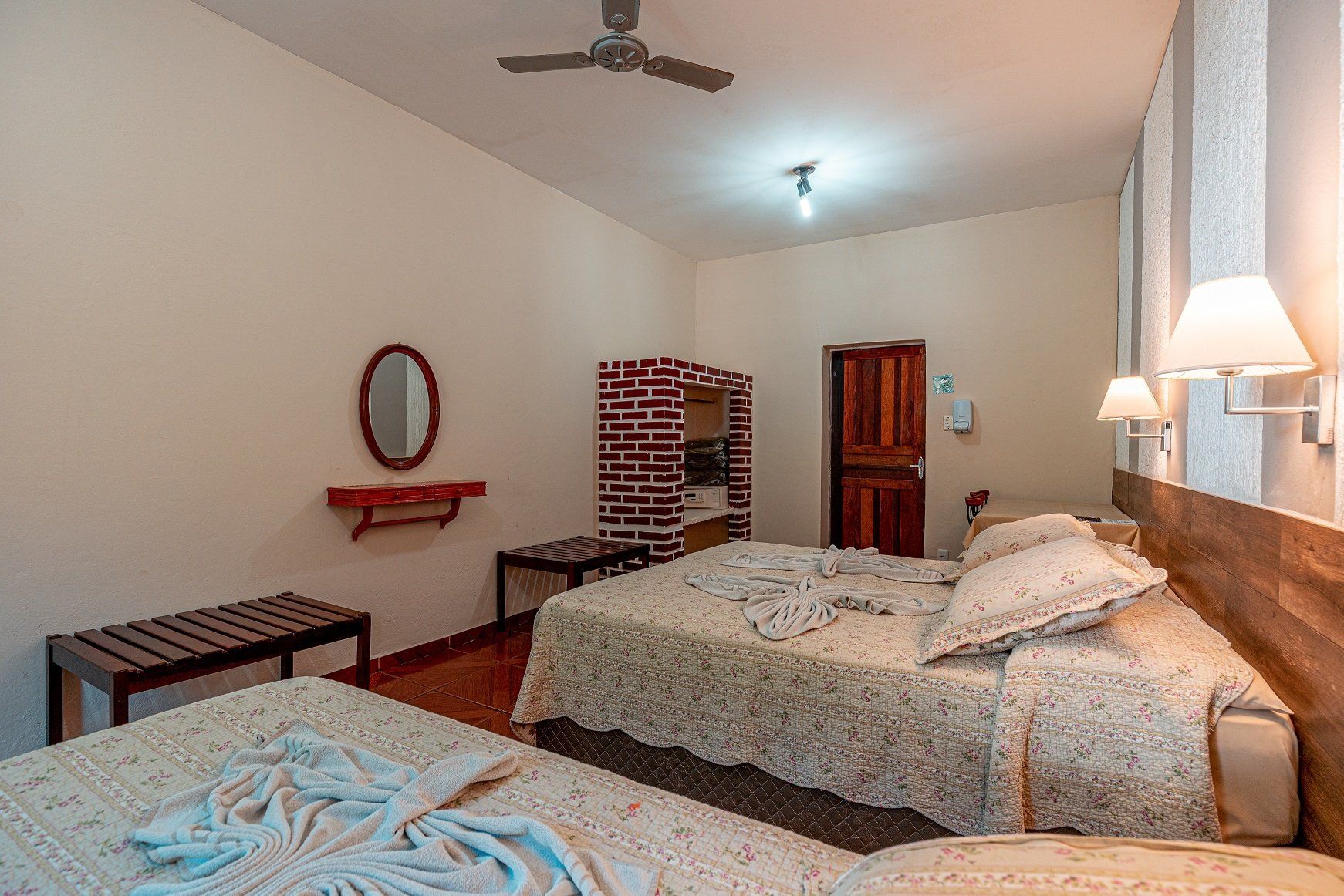 Quarto do Hotel Fazenda Santa Bárbara com parede de tijolinho aparente