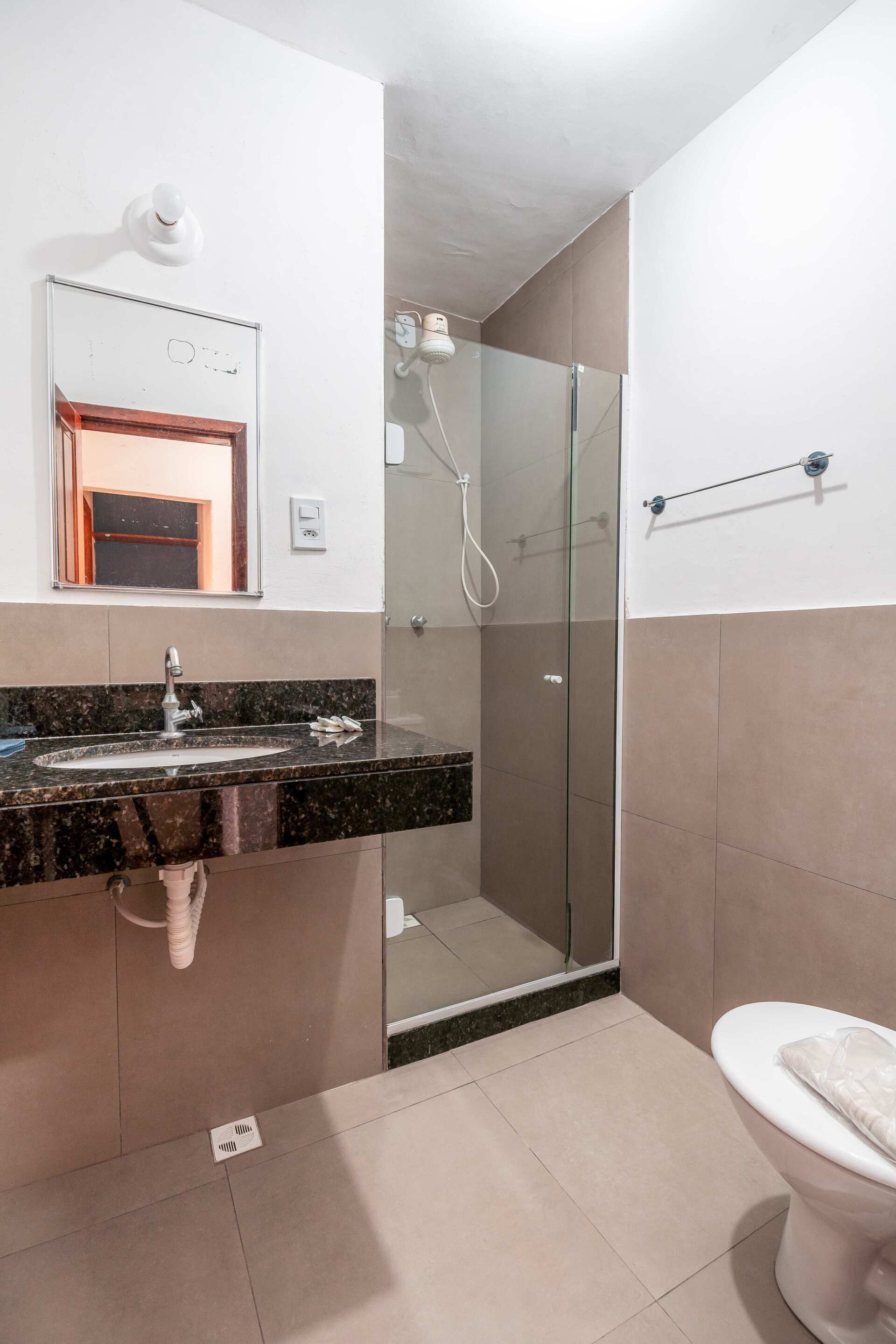 Banheiro de apartamento do Hotel Fazenda Santa Bárbara com box e chuveiro