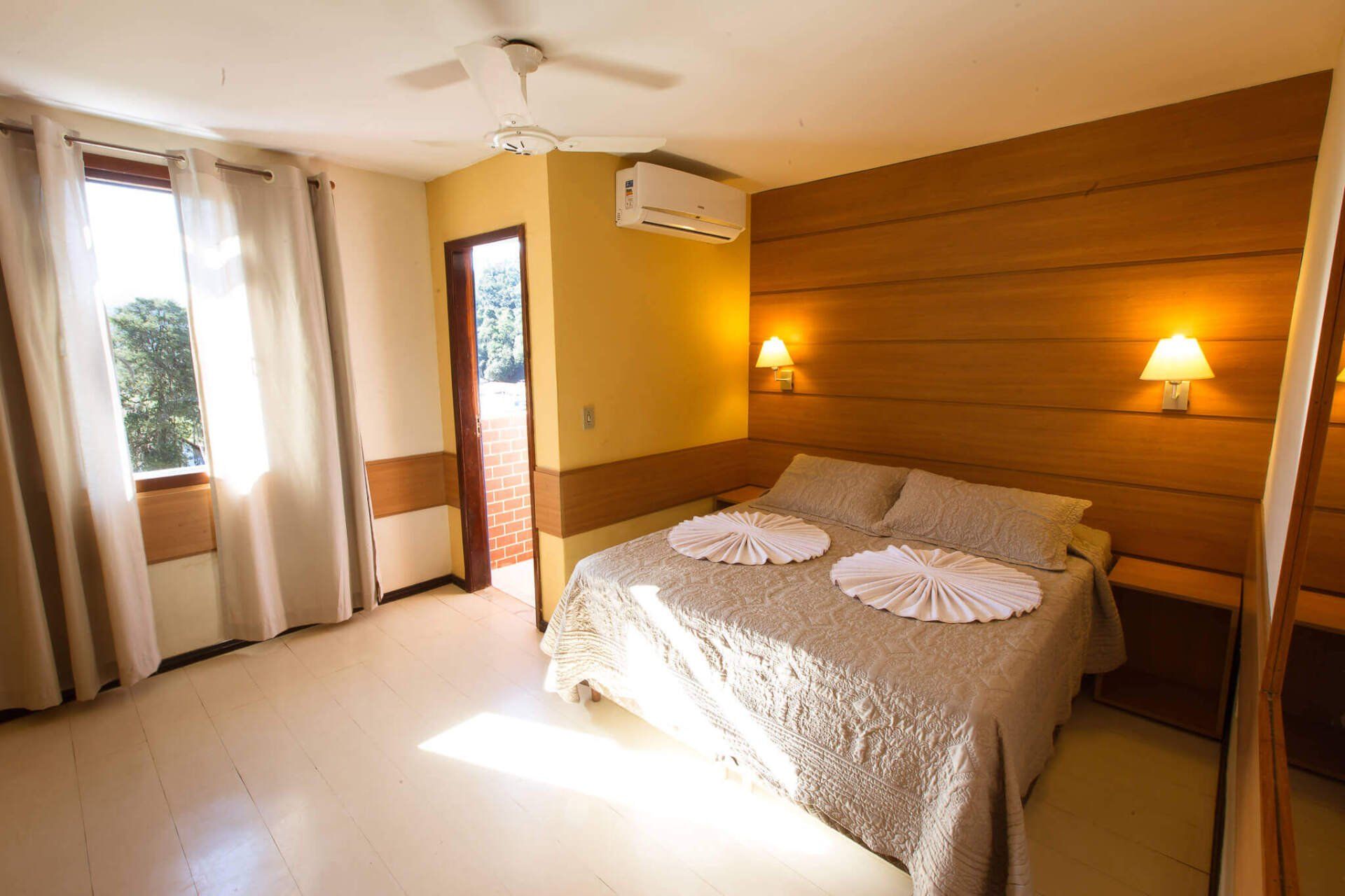 Quarto do Hotel Fazenda Santa Bárbara com cortinas e ar-condicionado