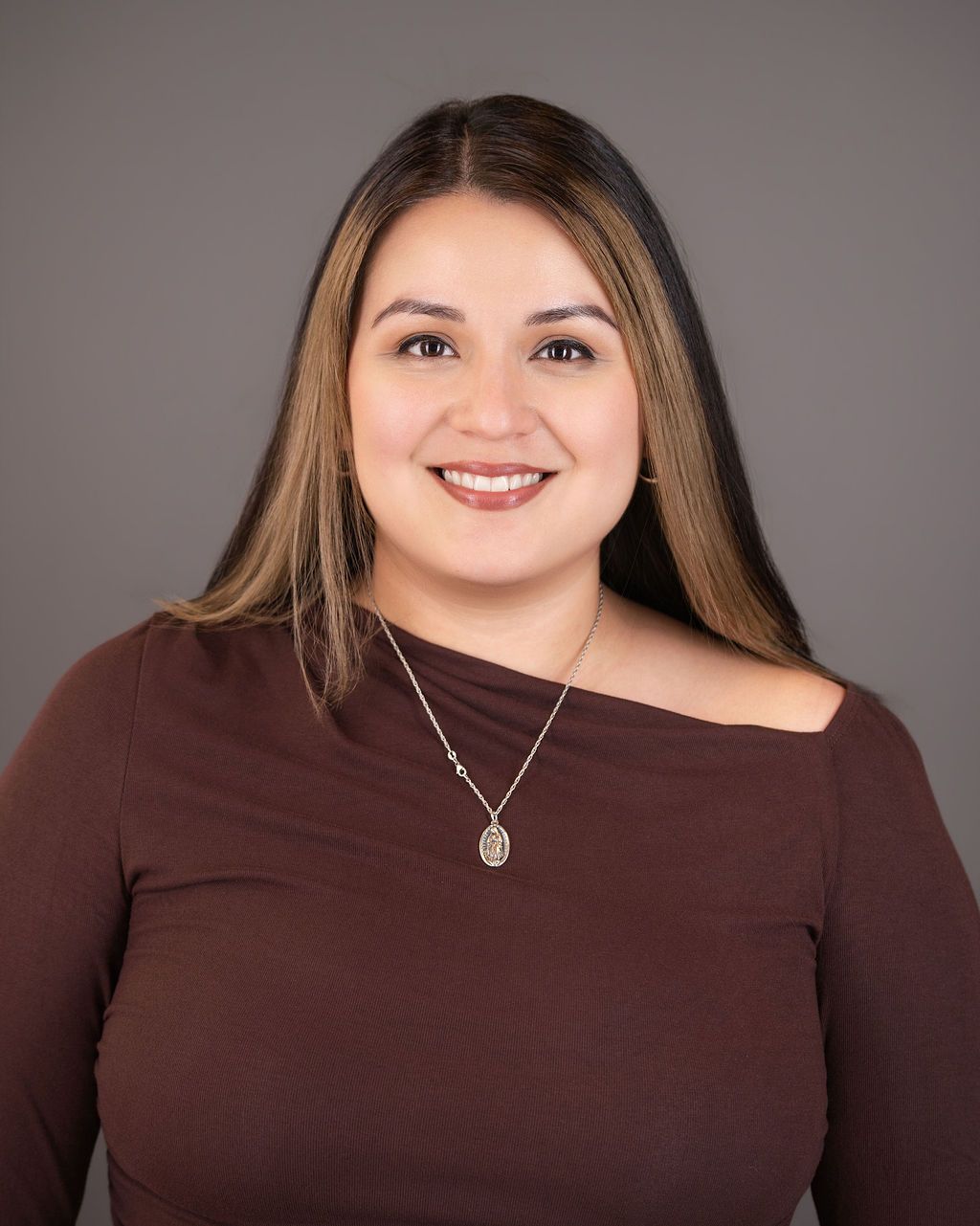 A woman in a maroon blouse smiling in a professional headshot
