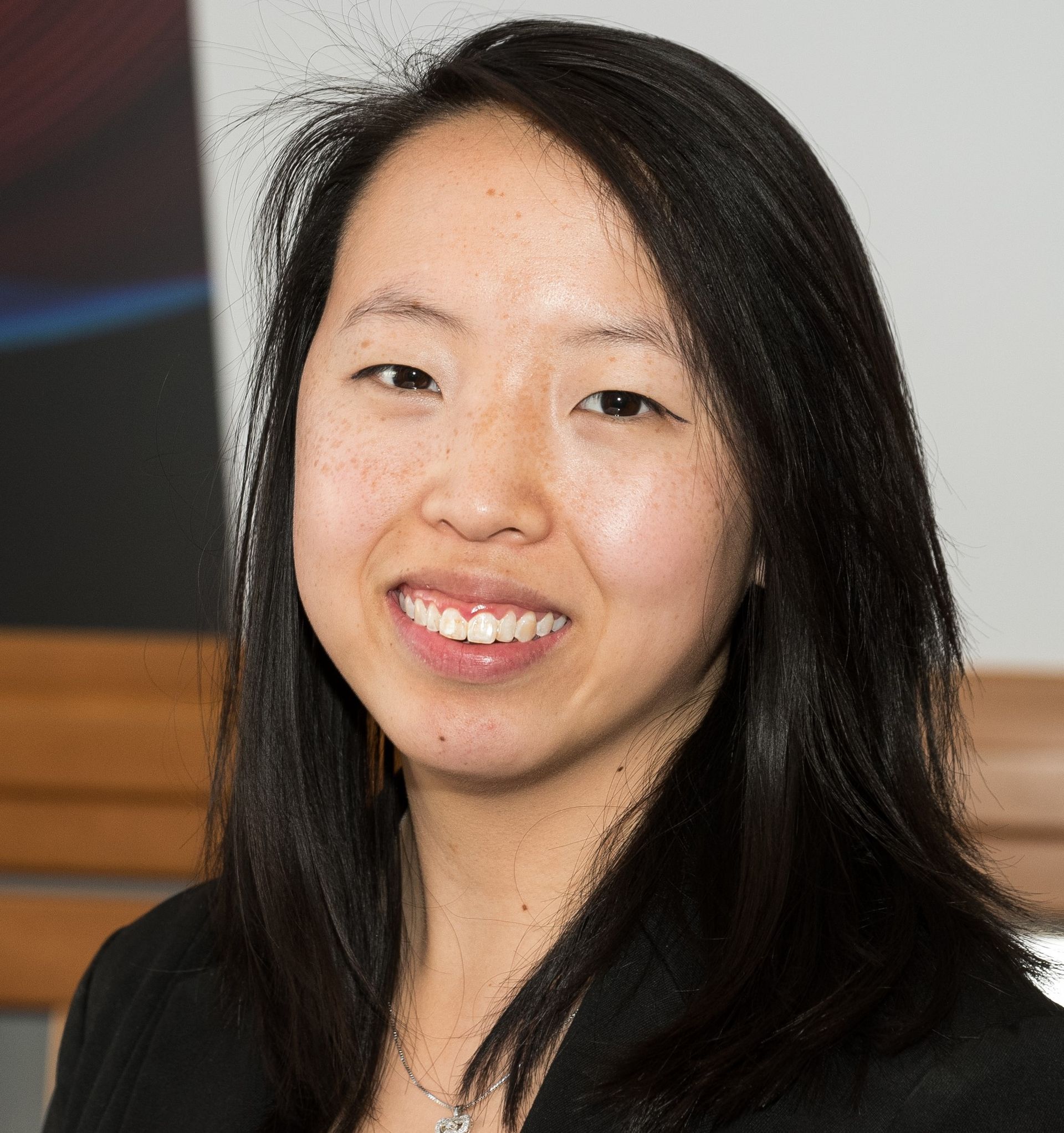 Woman in a black jacket smiles in a professional headshot.