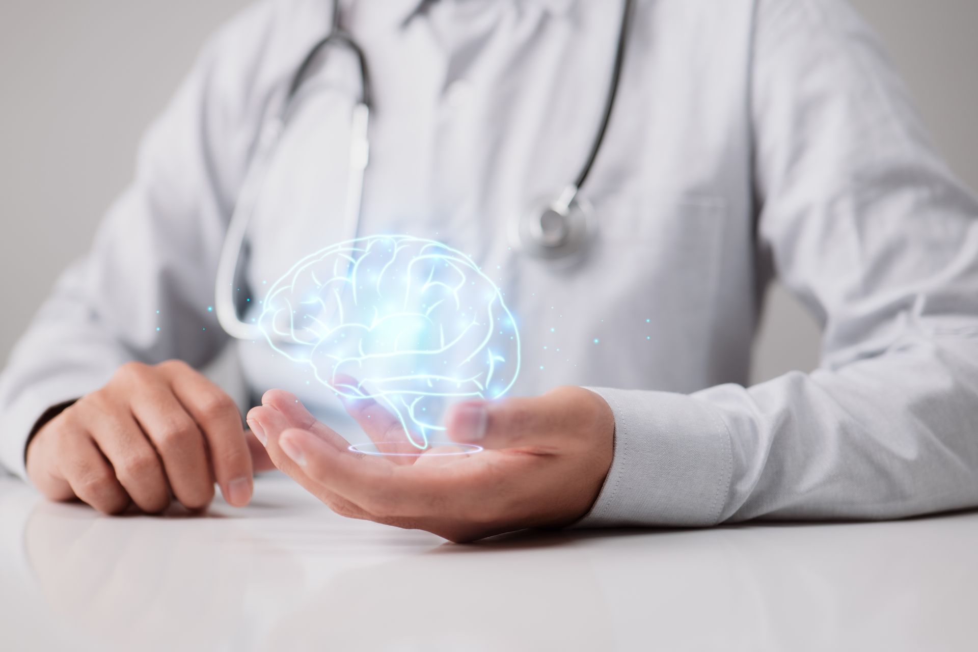 Médico com estetoscópio pendurado nos ombros segurando a imagem virtual de um cérebro em sua mão esquerda