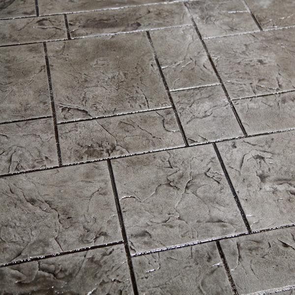 Gray stamped concrete patio with a stone pattern.