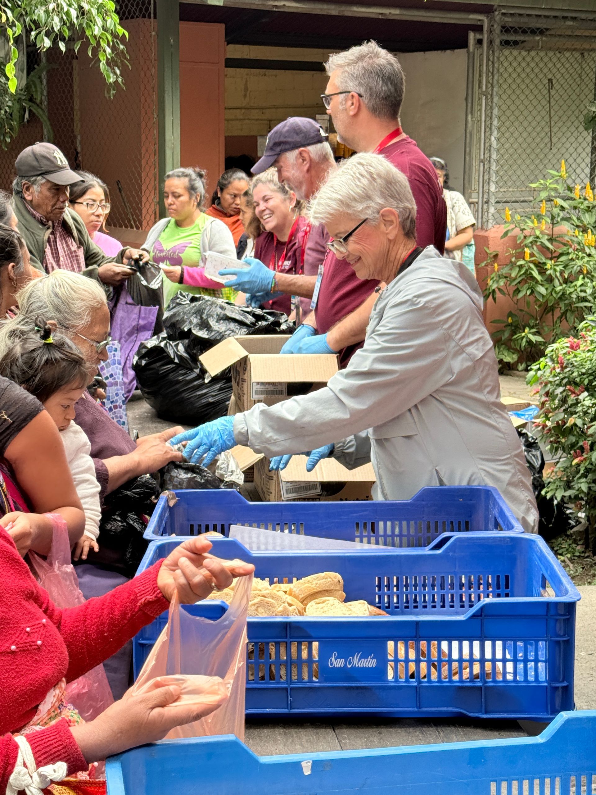 A group of people are standing around a row of blue crates.