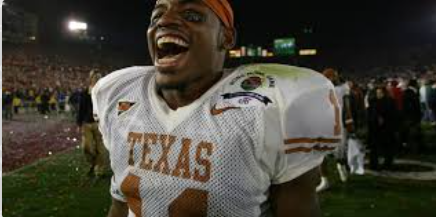 Football player in a white Texas uniform celebrates, mouth open, orange headband, confetti, stadium.