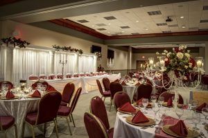 A large room with tables and chairs set up for a wedding reception.