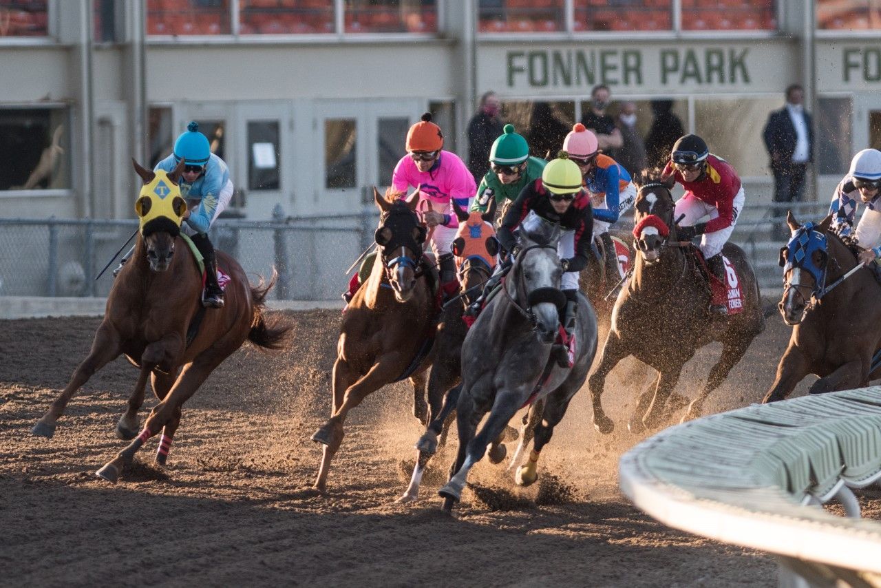 A group of horses are racing in front of a sign that says fonner park