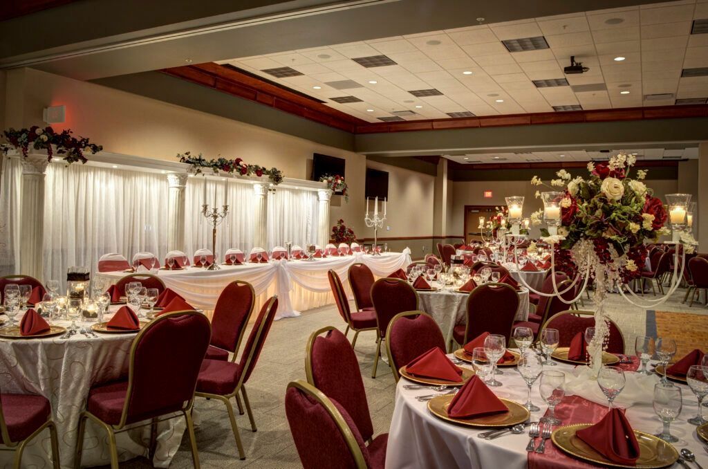 A large room with tables and chairs set up for a wedding reception.