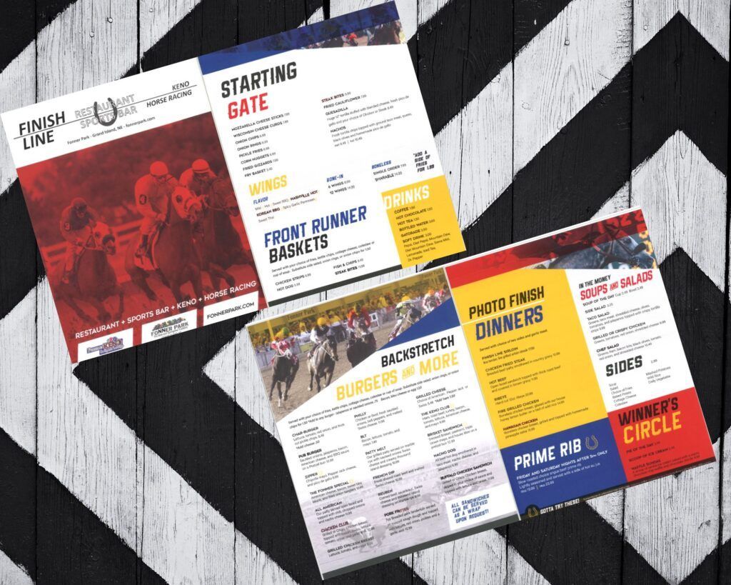 Three brochures are sitting on top of each other on a wooden table.