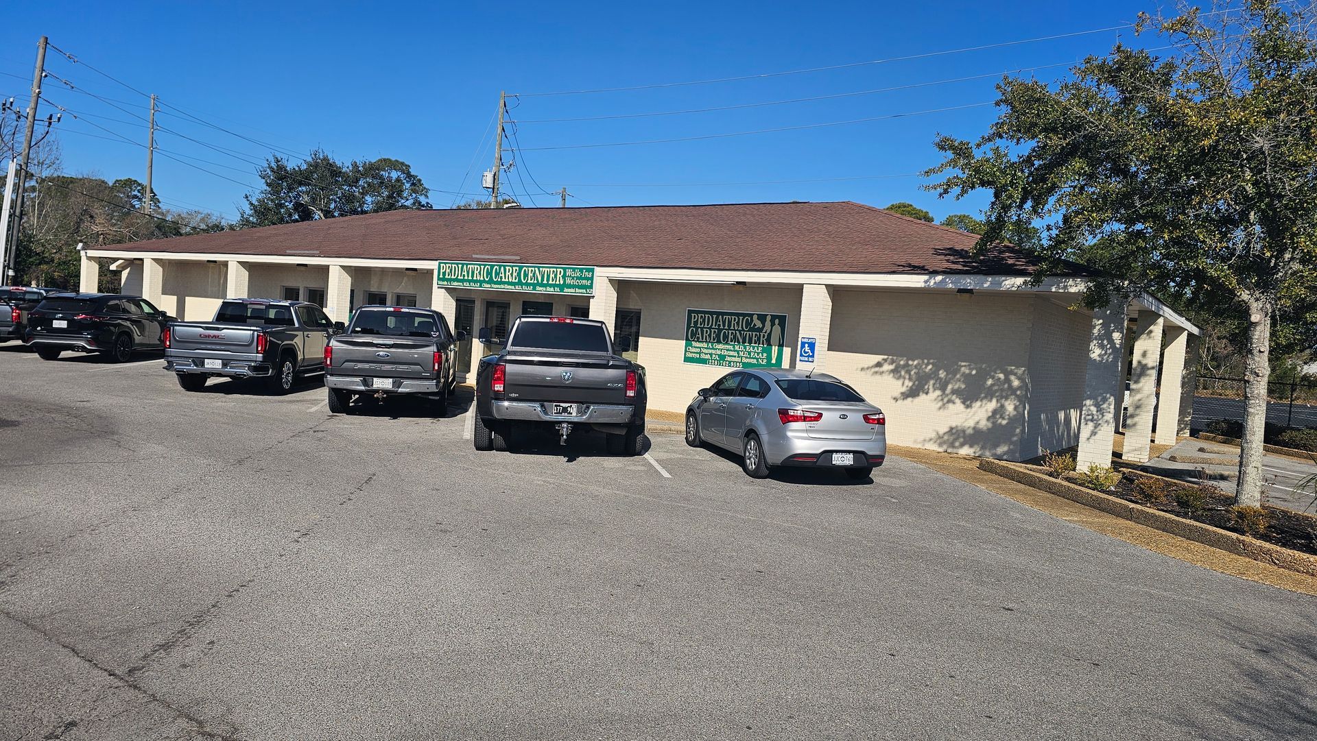 Single-story office building with parked cars in front on a sunny day