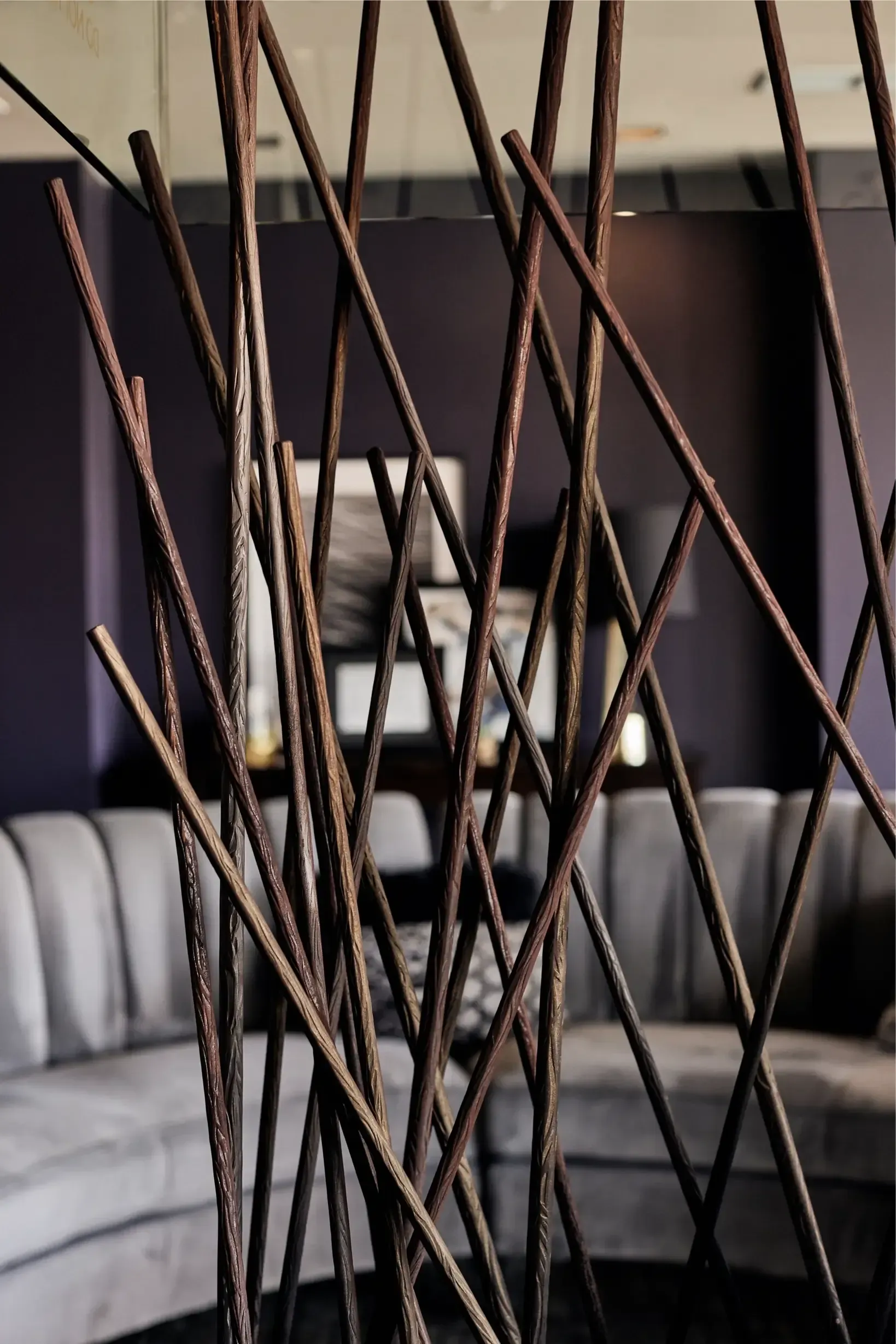 Interior lounge with a sculptural wooden twig divider and gray sectional seating at The Walkway, which offers Minneapolis apartments for rent.