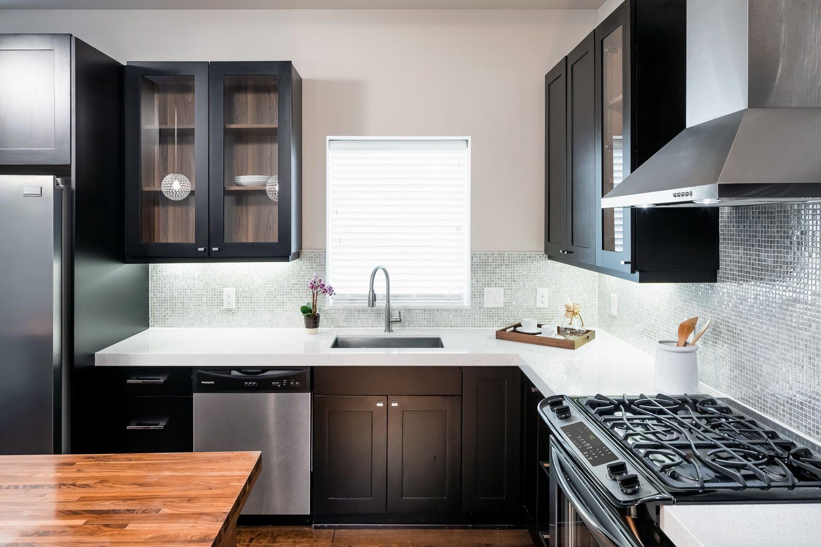 Modern kitchen with dark cabinets, stainless appliances, and a window above the sink at The Walkway, which offers apartments in Uptown Minneapolis, MN.