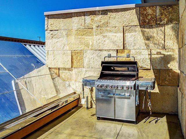 Outdoor grilling station on a stone-walled rooftop patio at The Walkway, which offers apartments for rent in Minneapolis, MN.