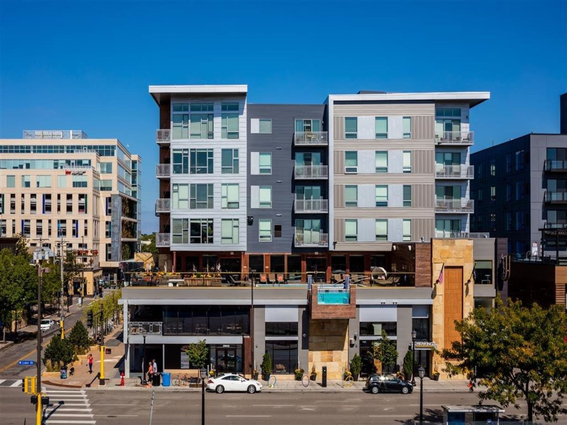 Exterior view of a modern, multi-story apartment building with balconies along a city street at The Walkway, which offers apartments in Minneapolis, MN.