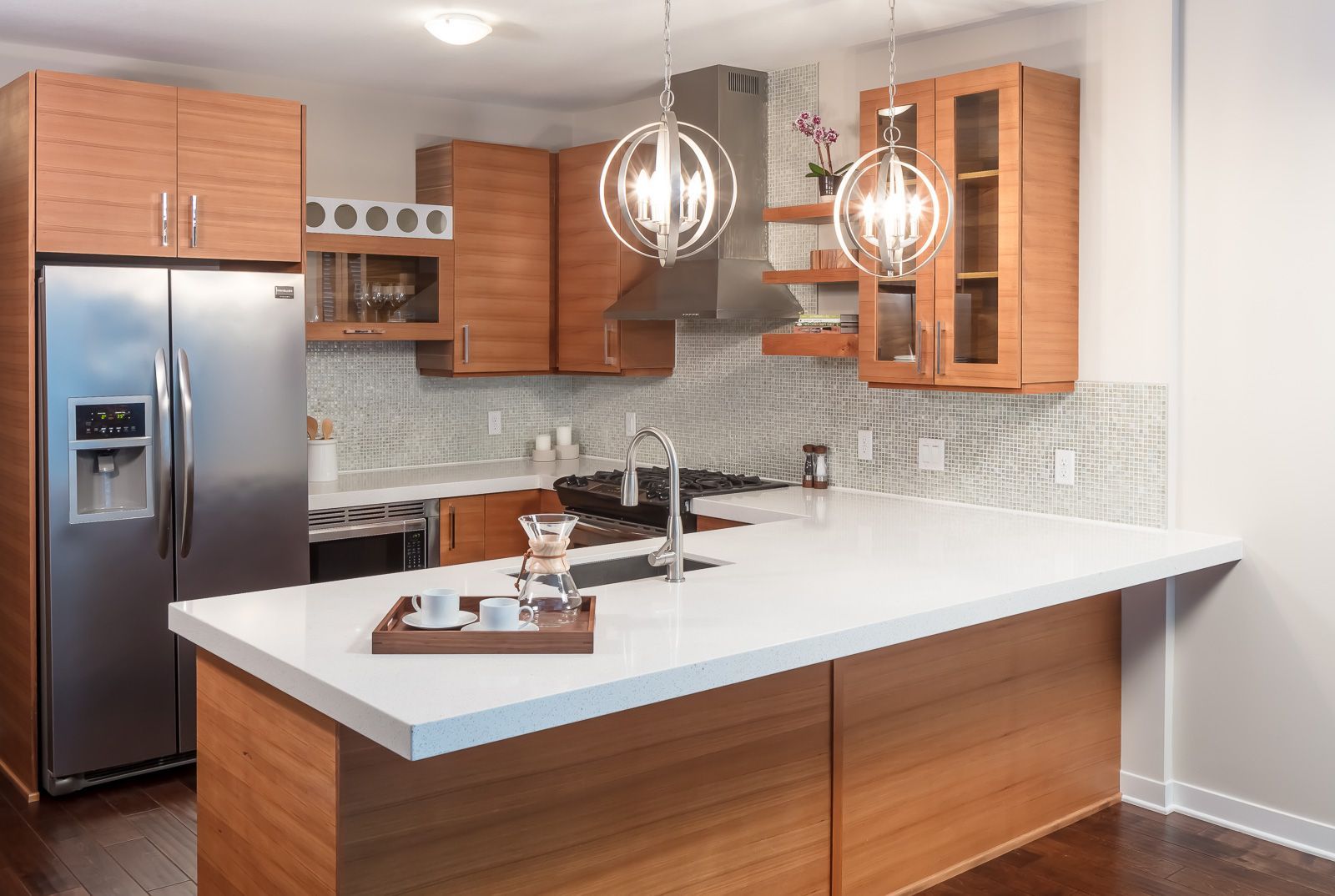 Modern kitchen with an island, wooden cabinets, stainless steel appliances, and pendant lights at The Walkway, which offers apartments in Uptown Minneapolis, MN.