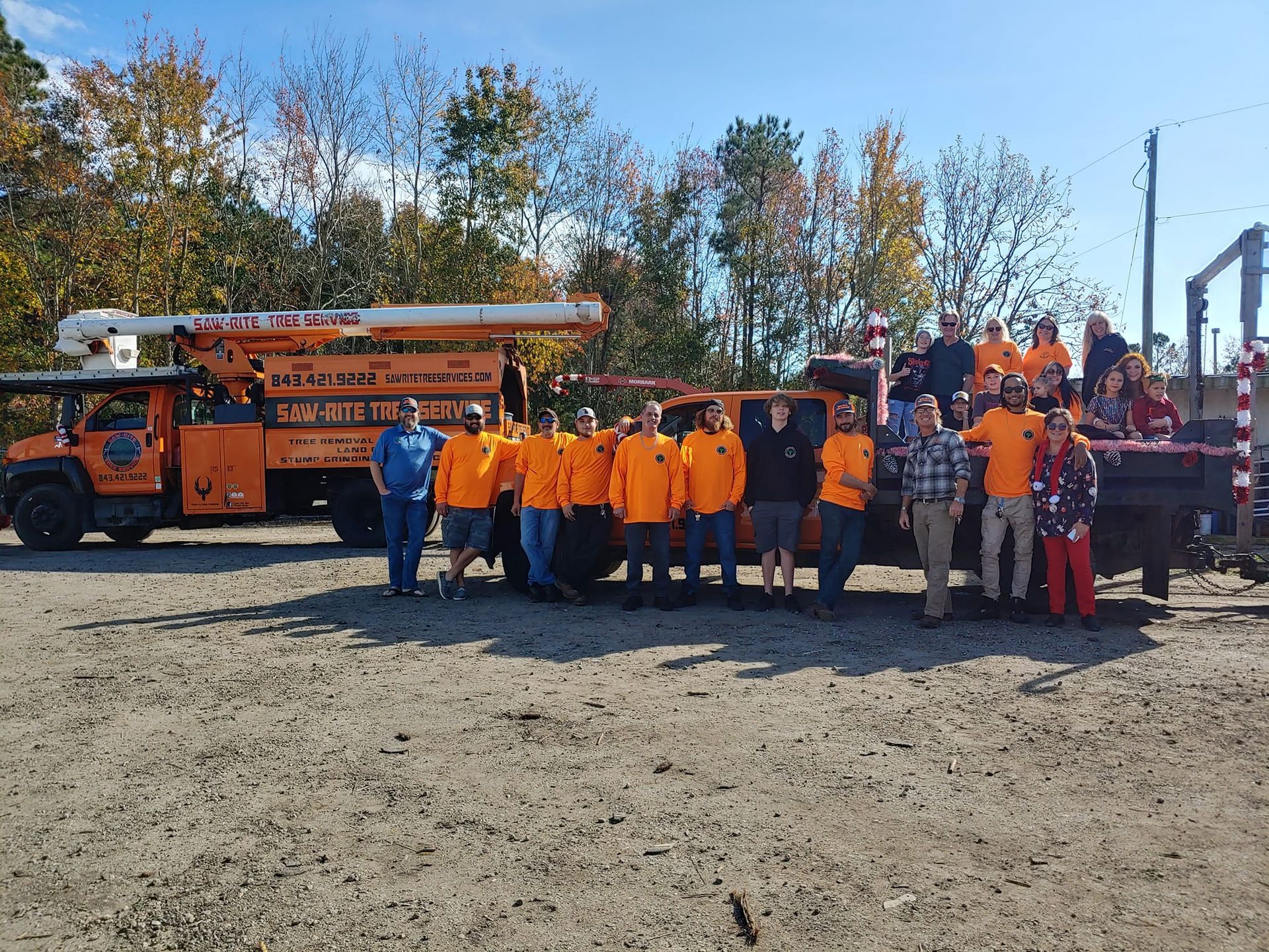 A group of people are posing for a picture in front of a truck.