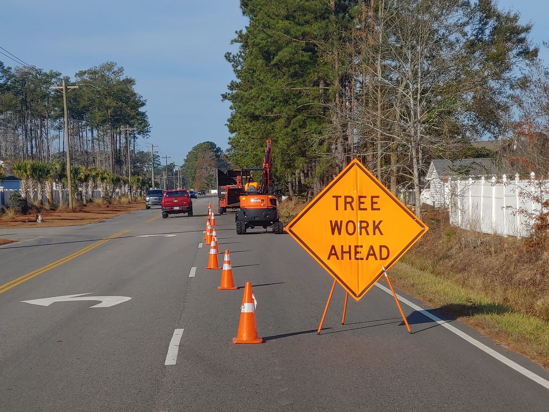 A sign on the side of a road that says tree work ahead