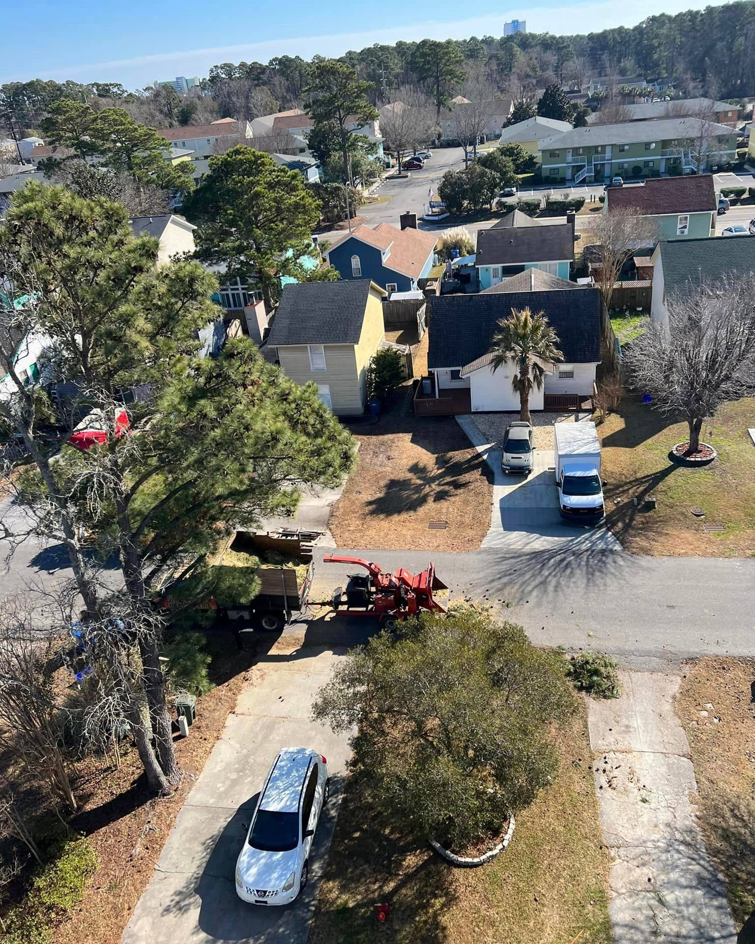 An aerial view of a residential neighborhood with a white van parked in the driveway.