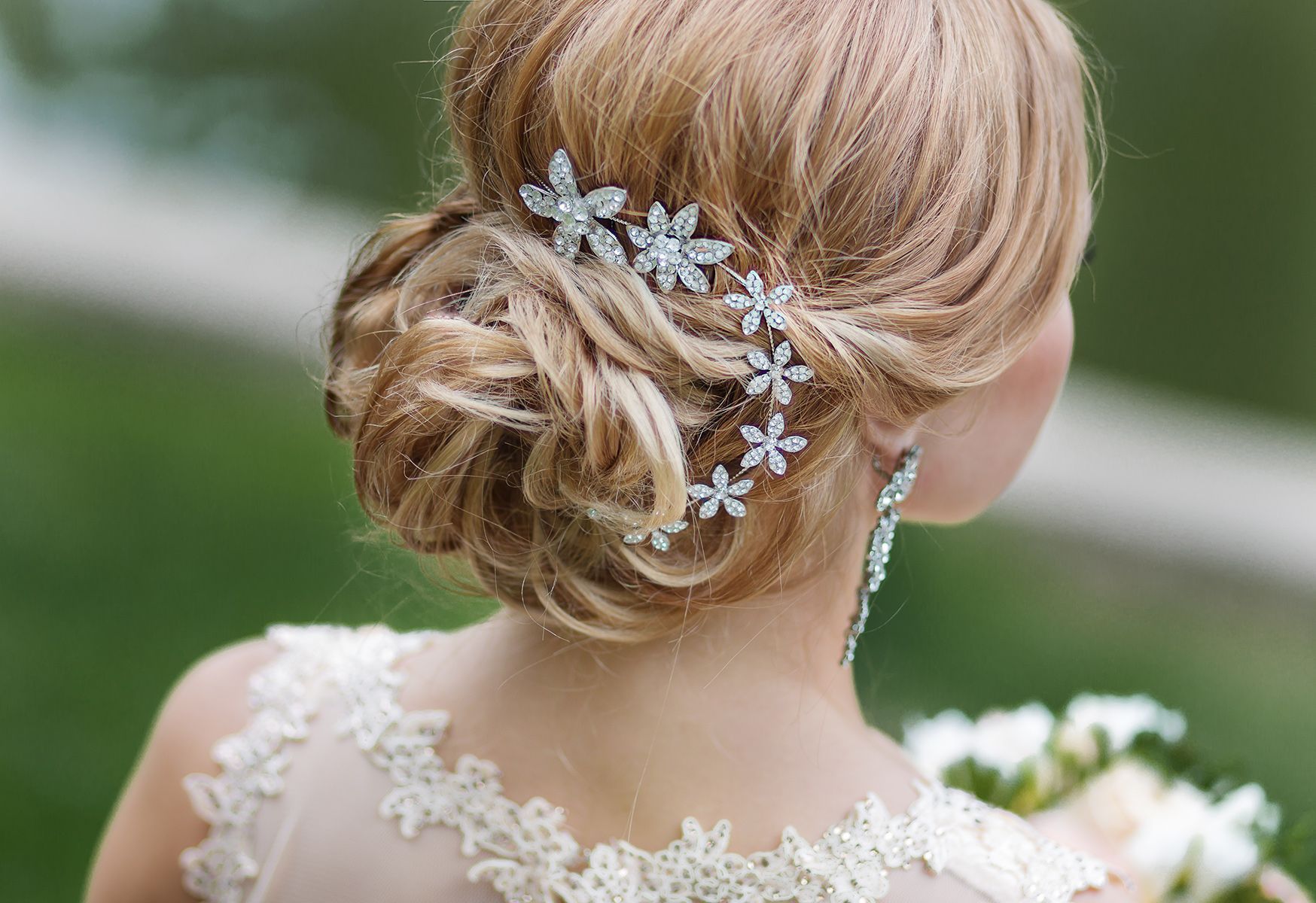 The back of a woman wearing a wedding dress and holding a bouquet of flowers — Janine Wellings Hair Art In Belmont, NSW