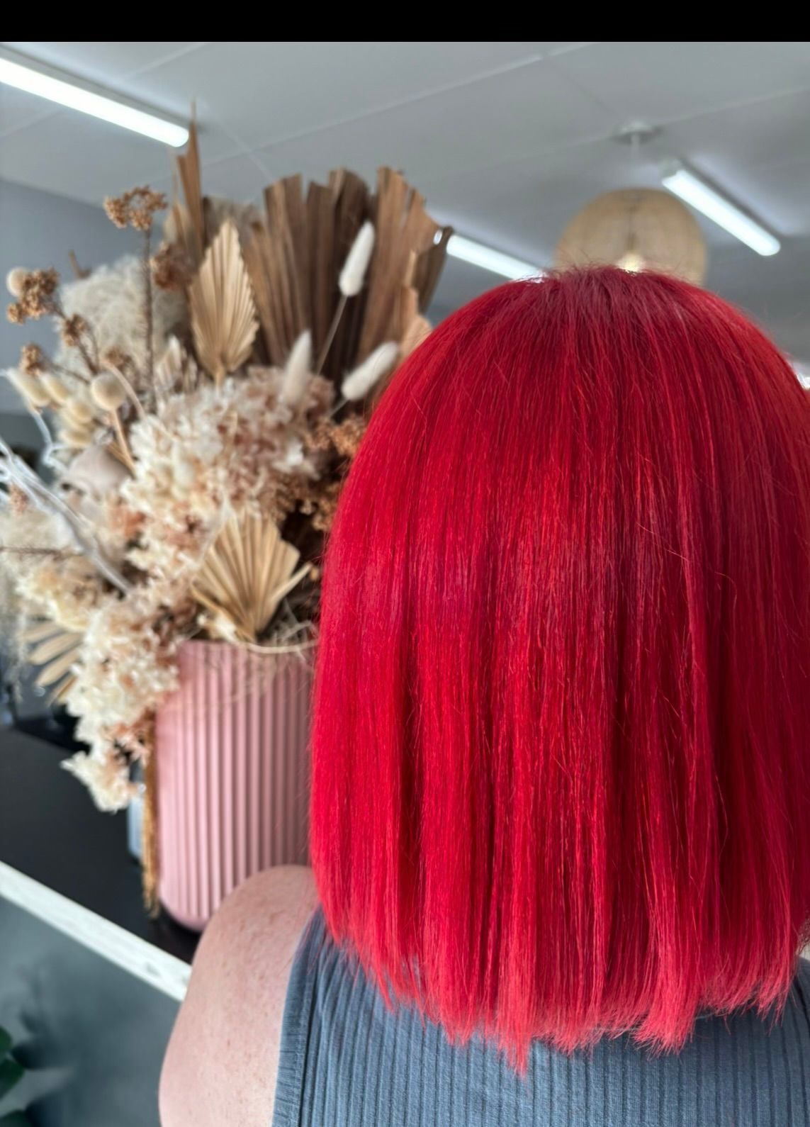 A Woman with dyed vibrant red hair— Janine Wellings Hair Art In Belmont, NSW