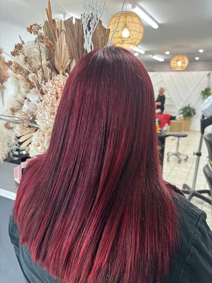 A Woman Is Getting Her Hair Cut In A Salon — Janine Wellings Hair Art In Belmont, NSW
