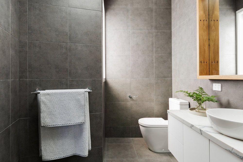 A Bathroom With a Toilet, Sink and Mirror — Maestro Tiling Services In Murrumbateman, NSW