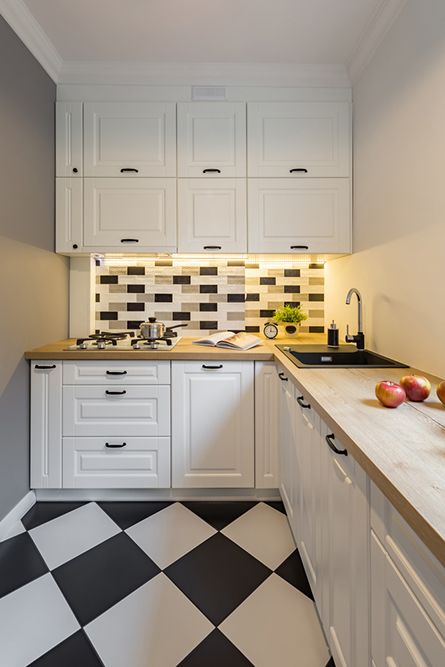 A Kitchen With White Cabinets and a Black and White Checkered Floor — Maestro Tiling Services In Gungahlin, ACT