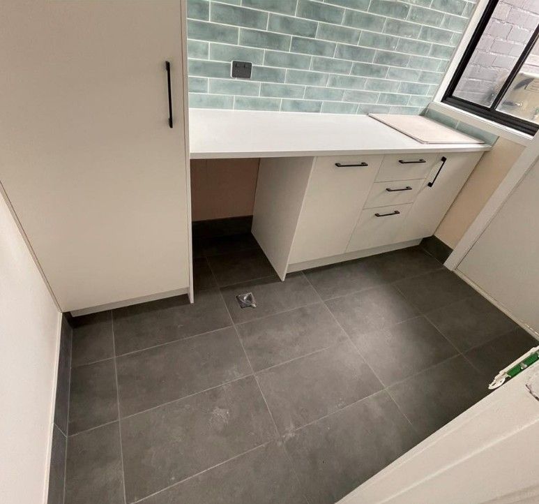 A Kitchen With White Cabinets and a Gray Tile Floor — Maestro Tiling Services In Latham, ACT