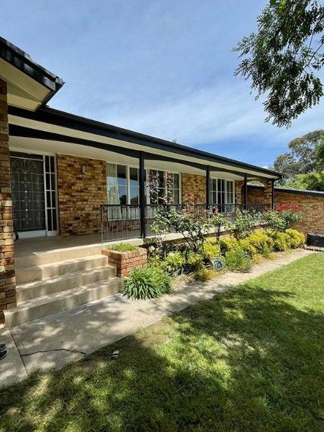A Large Brick House With a Large Lawn in Front of It — Maestro Tiling Services In Latham, ACT
