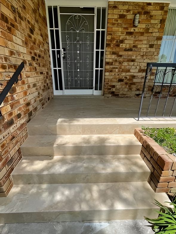 A Brick House With a Porch and Stairs Leading Up to the Front Door — Maestro Tiling Services In Latham, ACT