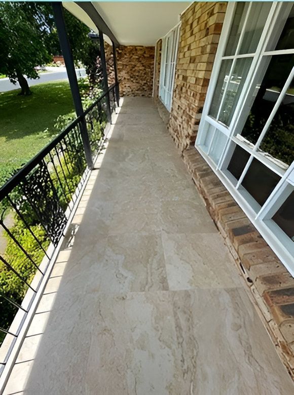 A Walkway Leading to a Brick Building With a Balcony — Maestro Tiling Services In Murrumbateman, NSW