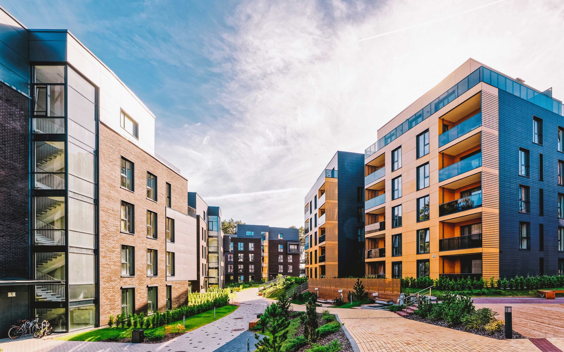 Immeubles d'appartements modernes en briques et panneaux colorés sous un ciel bleu.