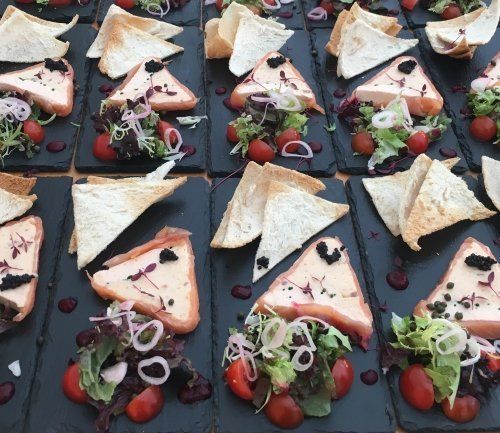 A table topped with plates of food including sandwiches and salads